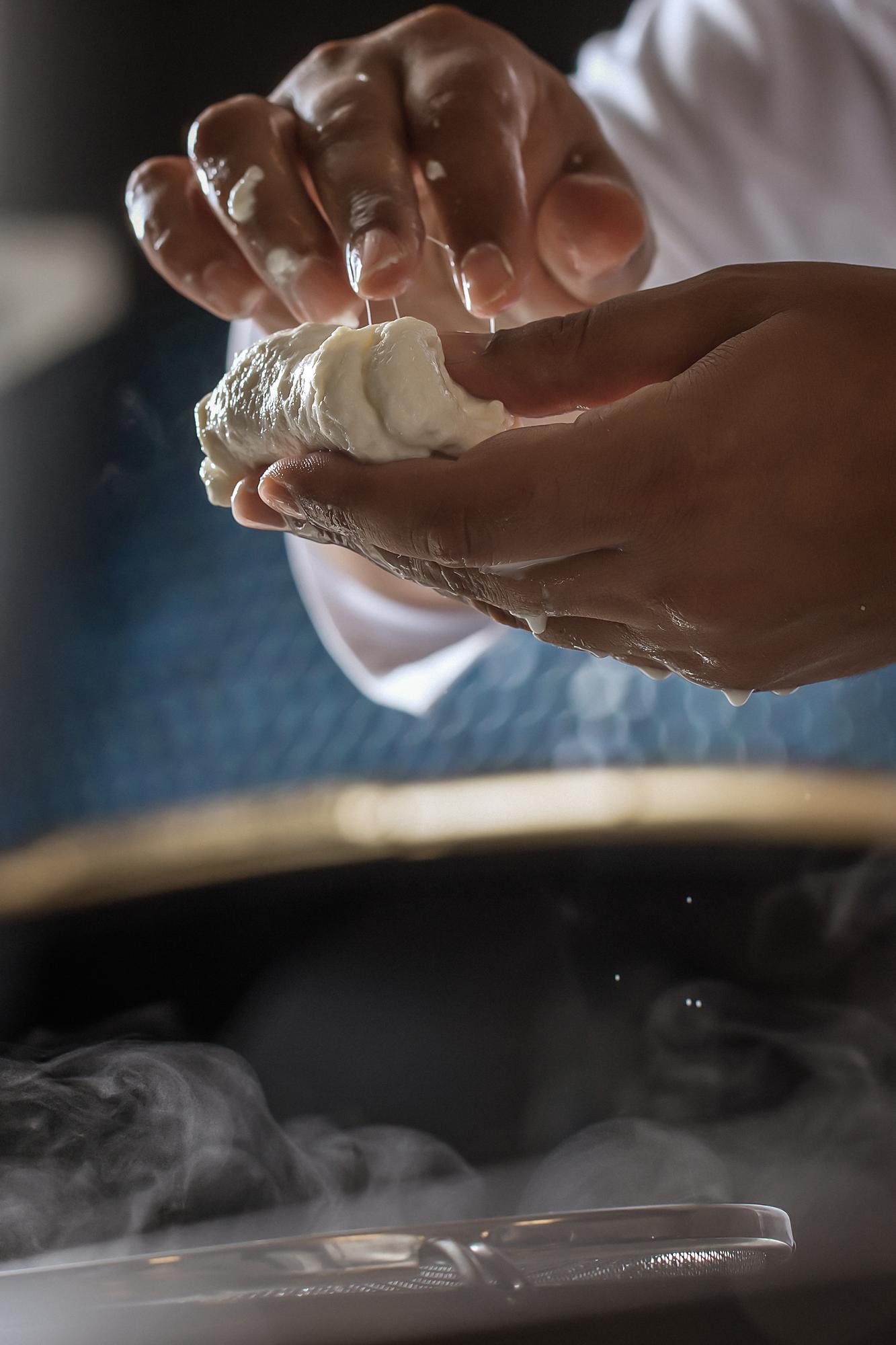 Close-up of hands kneading dough in a warm kitchen